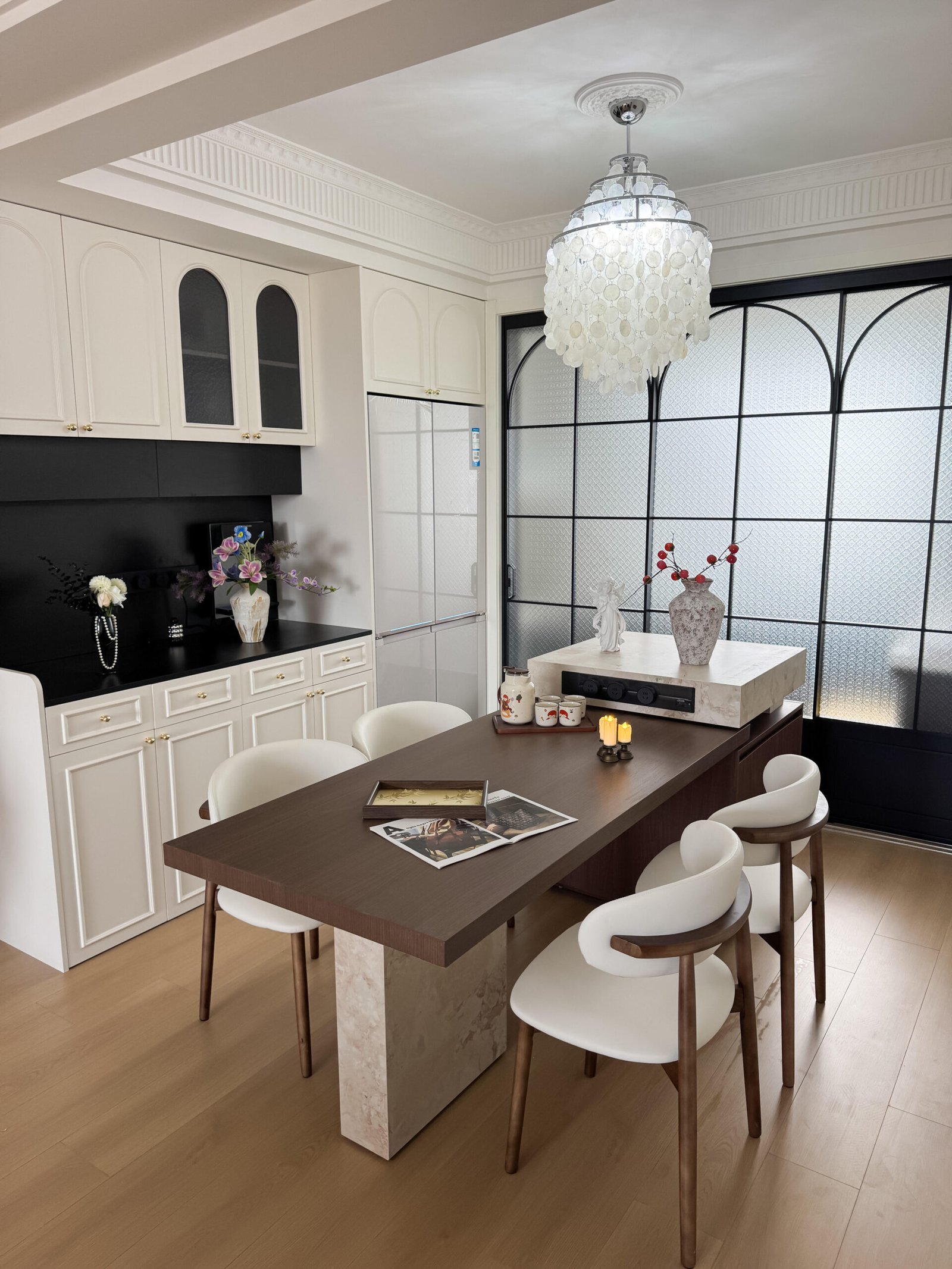 Modern classic Dining Table Set for 4 beside black-framed glass doors.