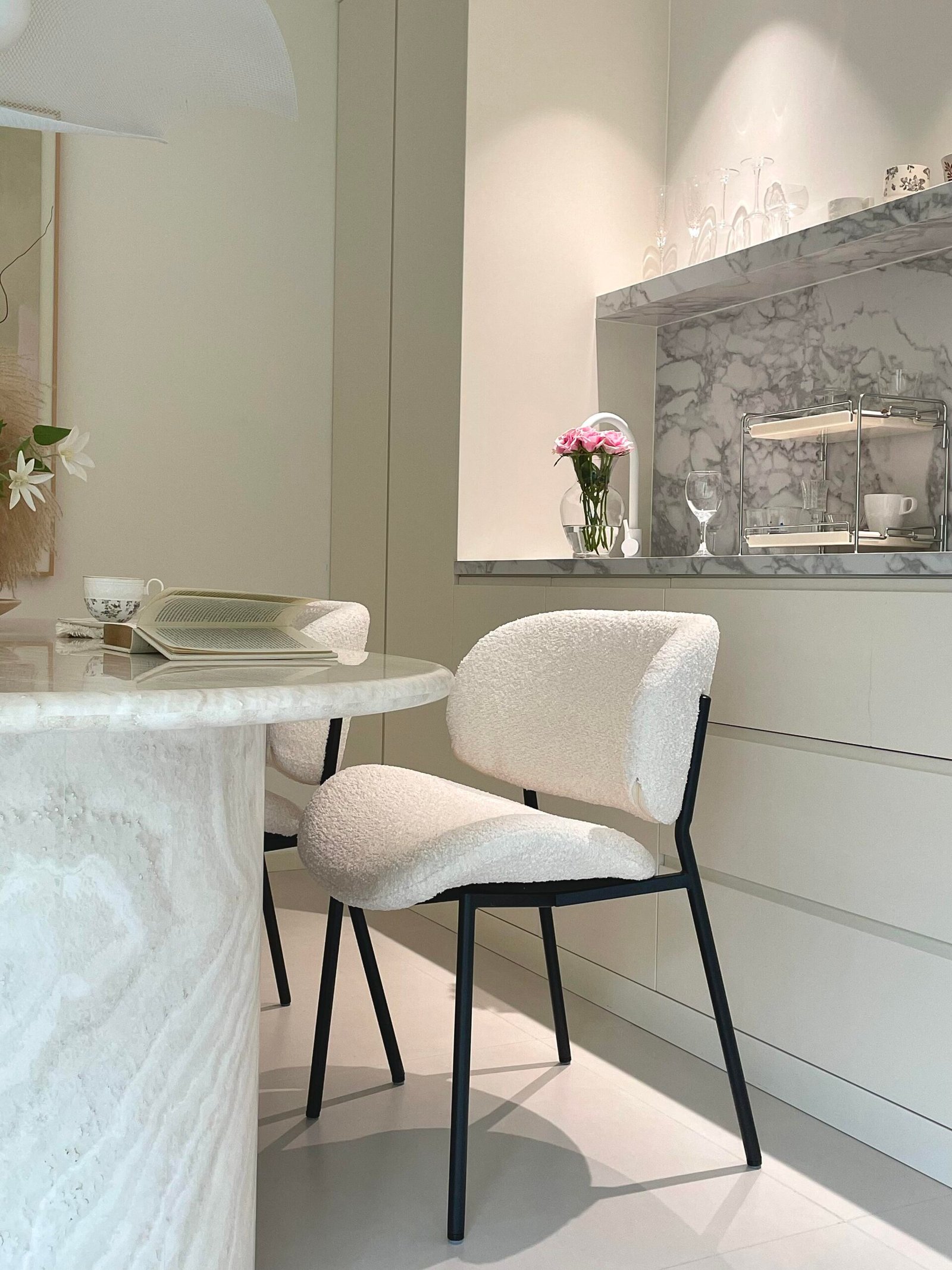 Marble introduces elegance without requiring elaborate decoration. The table and kitchen backsplash work together to create continuity between the dining and kitchen zones. Large stone surfaces naturally become decorative elements because of their unique veining patterns. Pairing marble with soft fabrics and warm lighting prevents the space from feeling cold or overly formal. For a more budget-friendly version, high-quality marble-look porcelain or quartz can achieve a similar visual effect with easier maintenance.