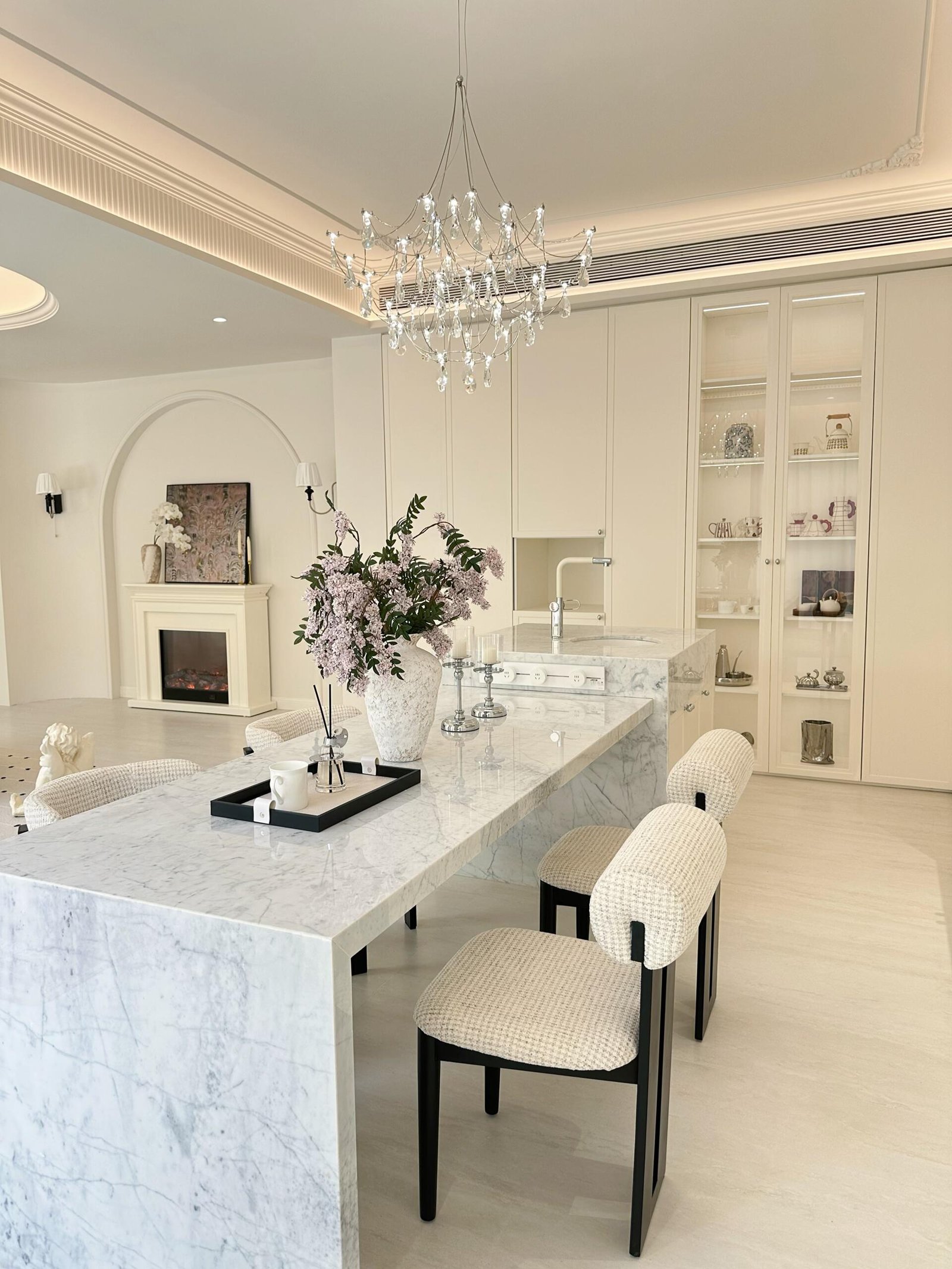 White marble dining table surrounded by comfortable beige upholstered chairs