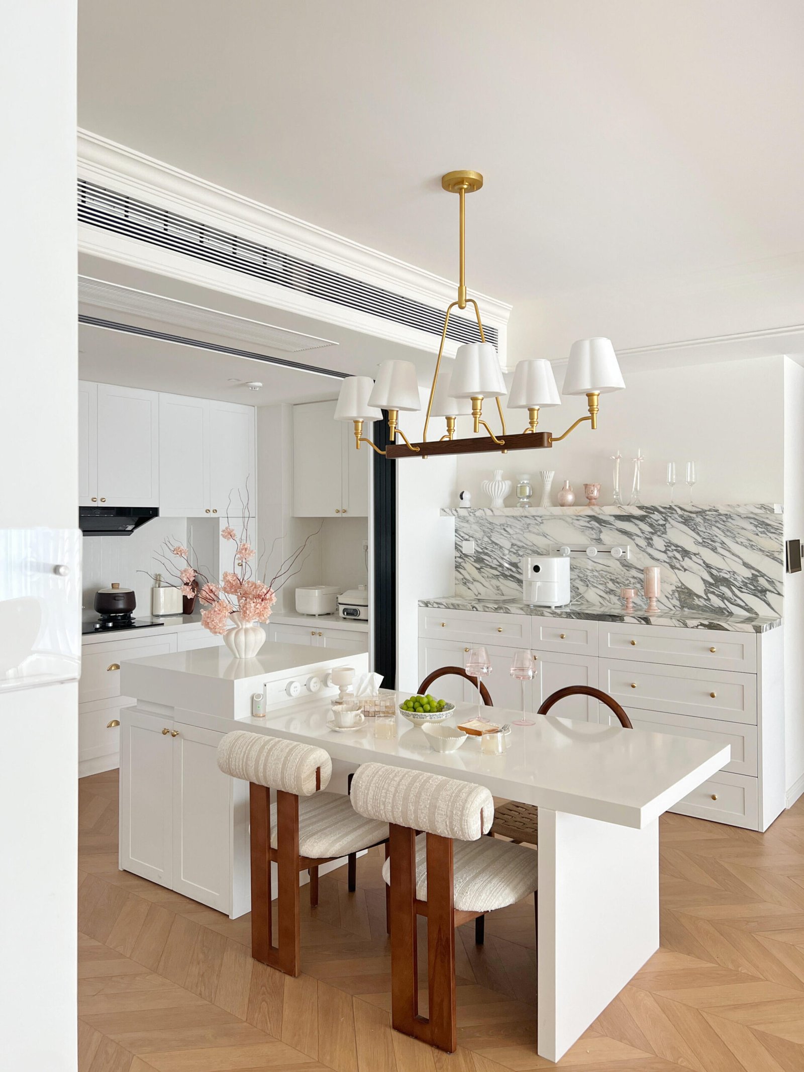 Minimalist dining room with warm wood flooring and soft cream curtains