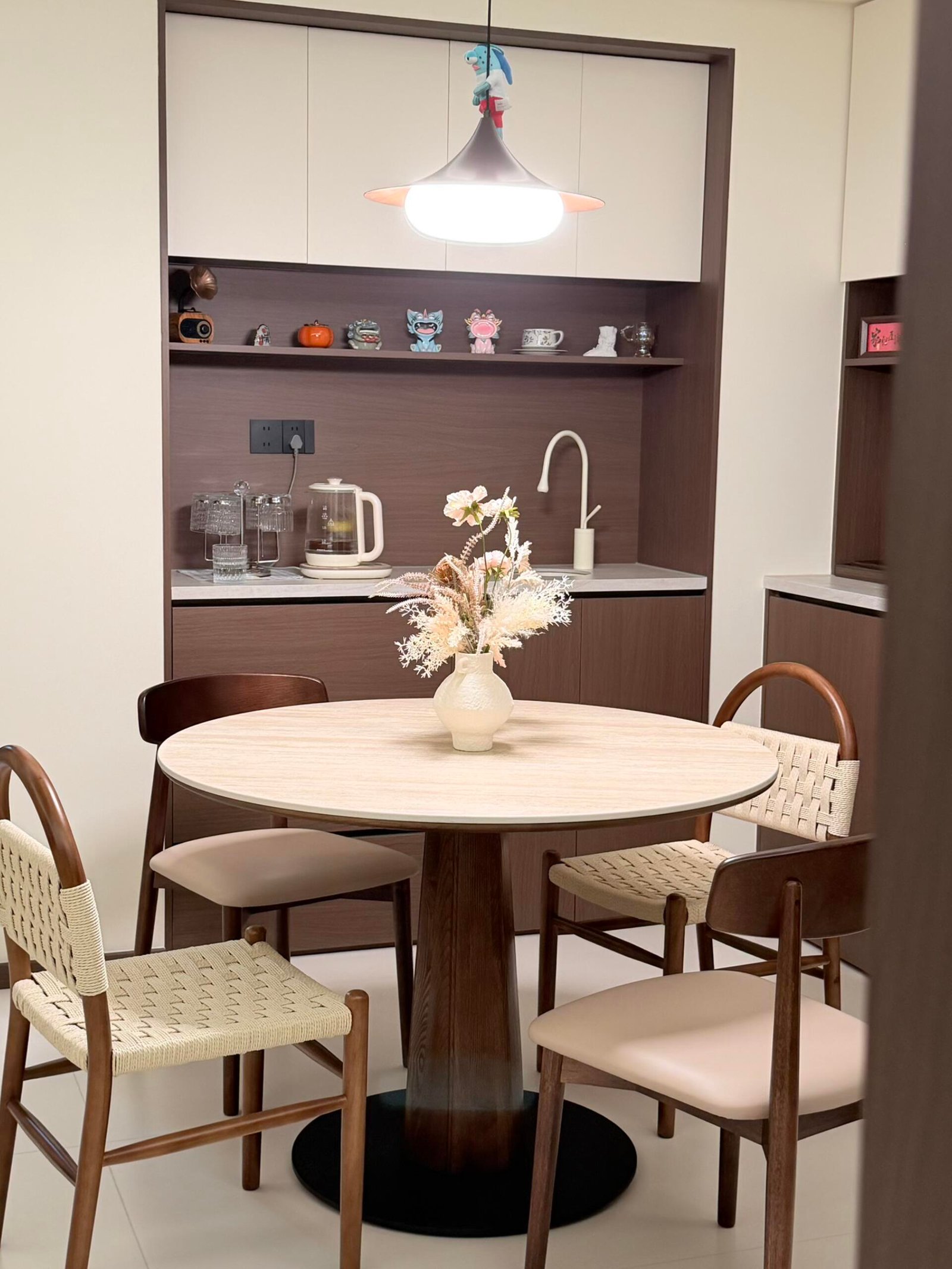 Round wood Dining Table Set for 4 with woven chairs and warm cabinetry.