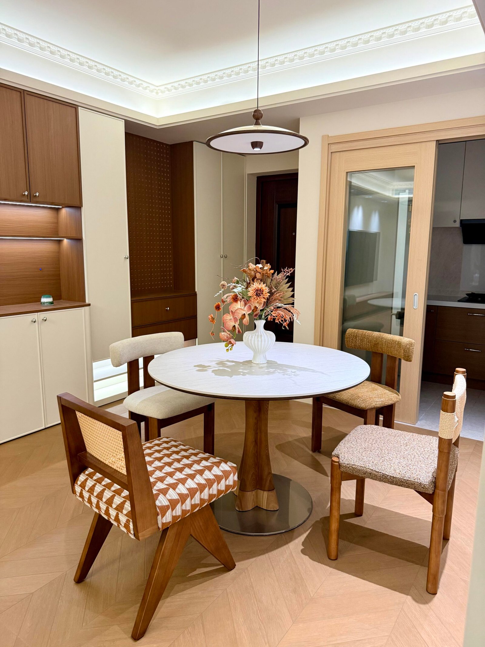 Round Dining Table Set for 4 with mixed wood chairs and warm cabinetry.