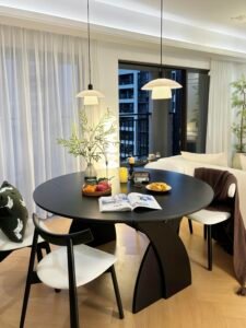 Bright contemporary dining area with floor to ceiling windows and stone flooring