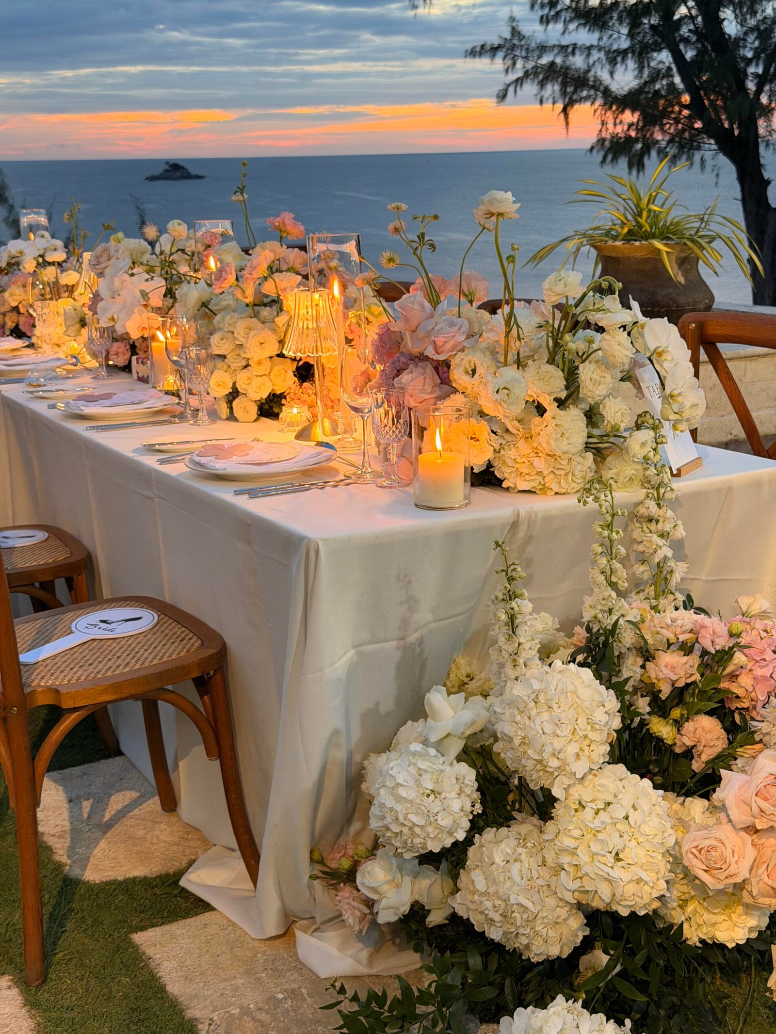Romantic tropical wedding tablescape with hydrangeas and trailing florals