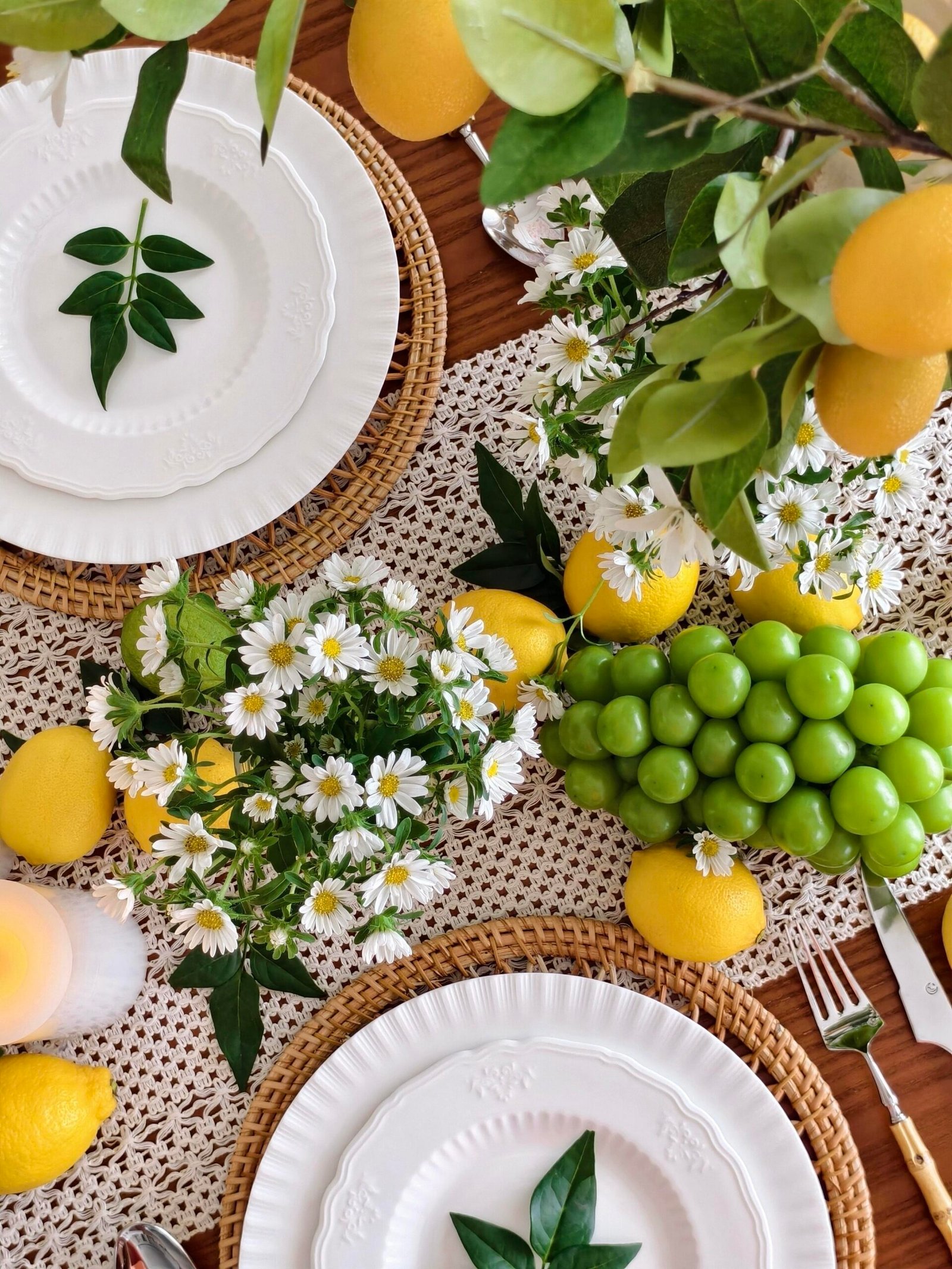 Bamboo-handled flatware paired with citrus branch and daisy table styling