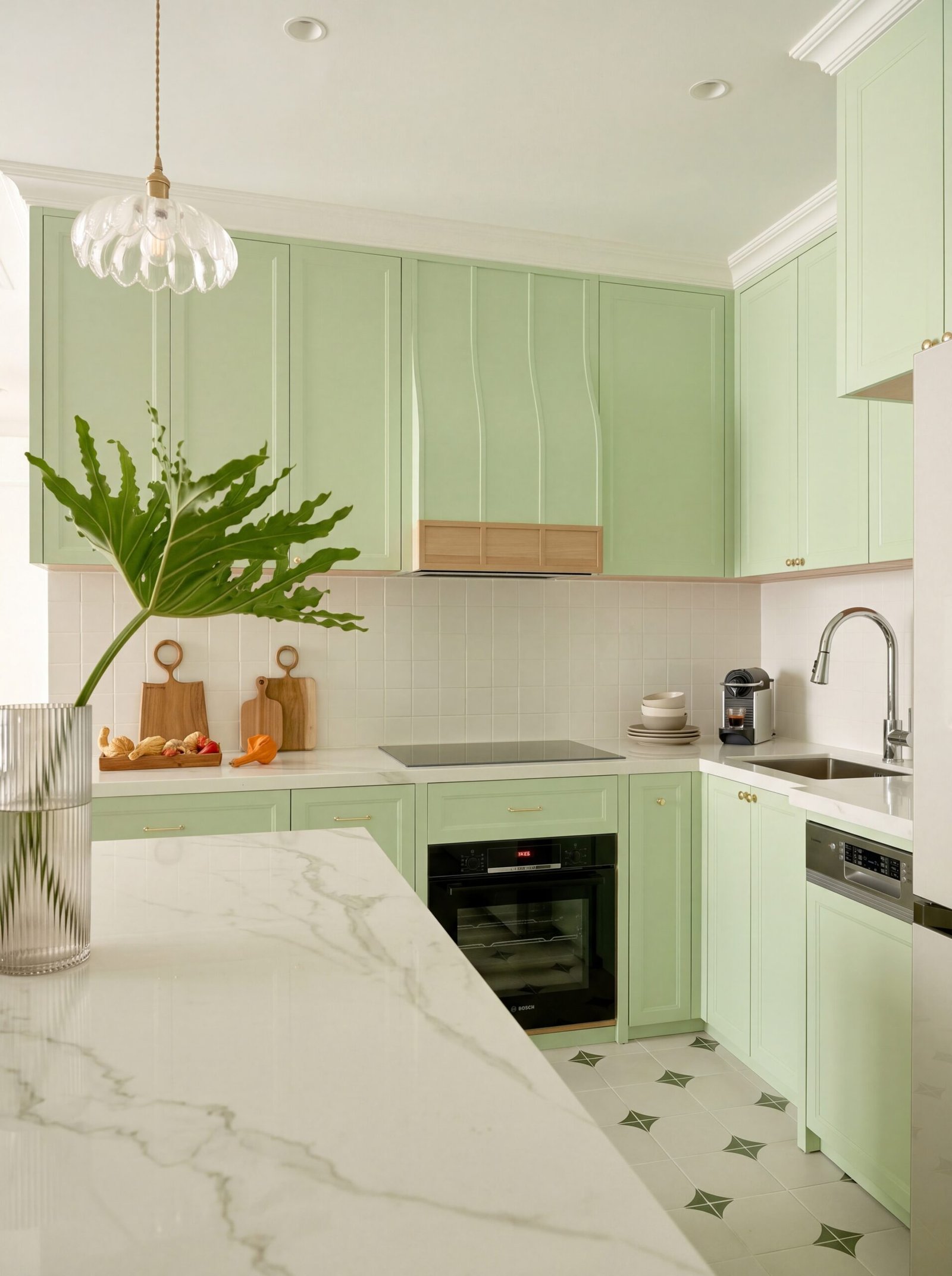 Sage green U-shaped kitchen with marble waterfall island and wood-trimmed range hood.